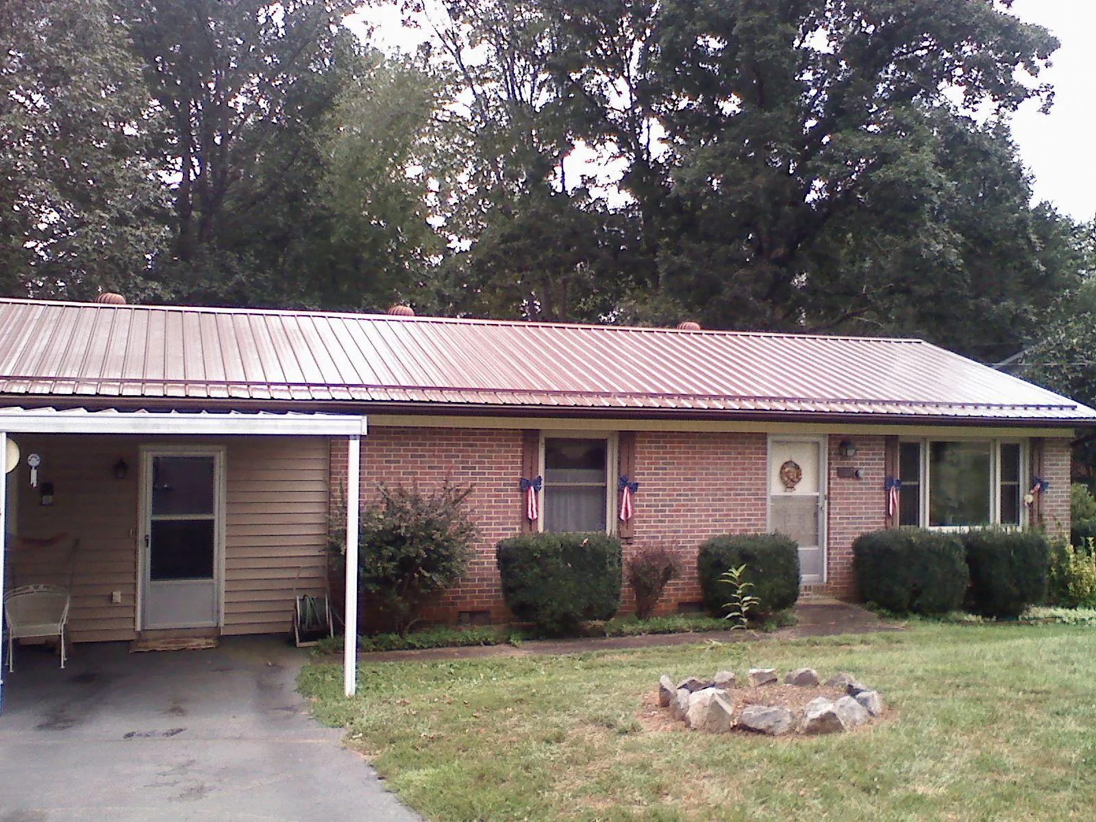 Bronze metal roof and carport on a brick ranch home — Roof Repair work by our crew in Alvo